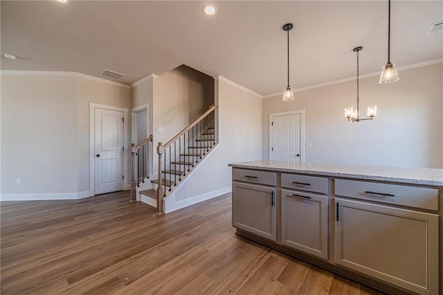 kitchen featuring visible vents, light wood-style flooring, gray cabinets, ornamental molding, and baseboards