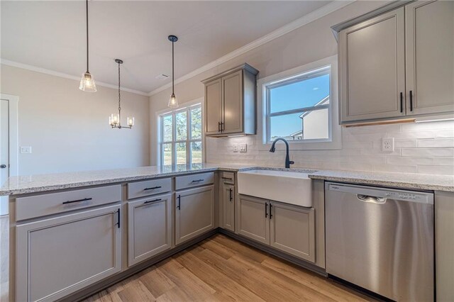 kitchen featuring a peninsula, a sink, gray cabinetry, dishwasher, and crown molding