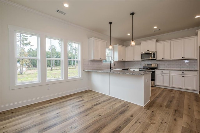 kitchen with visible vents, stainless steel appliances, light wood-style floors, and decorative backsplash