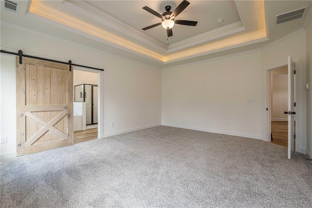 interior space featuring a tray ceiling, visible vents, and carpet floors