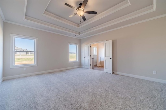 unfurnished bedroom featuring a raised ceiling, ornamental molding, baseboards, and light carpet