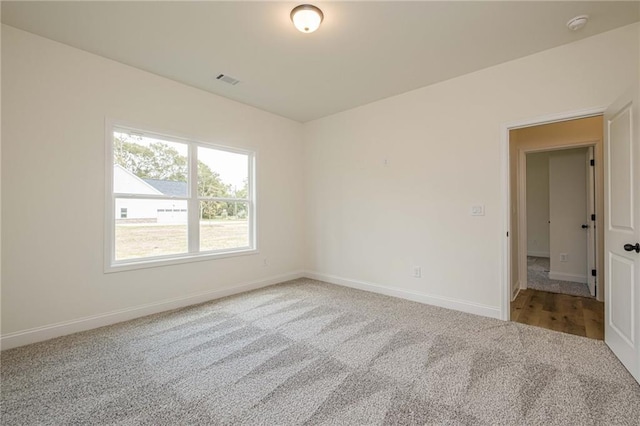 spare room with visible vents, baseboards, and carpet