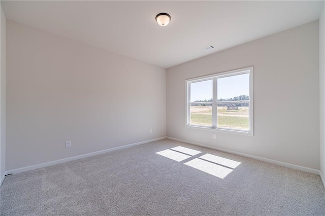 carpeted empty room featuring visible vents and baseboards