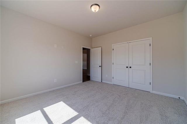 unfurnished bedroom with a closet, baseboards, and carpet floors