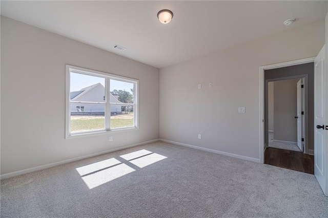 unfurnished room with visible vents, baseboards, and carpet