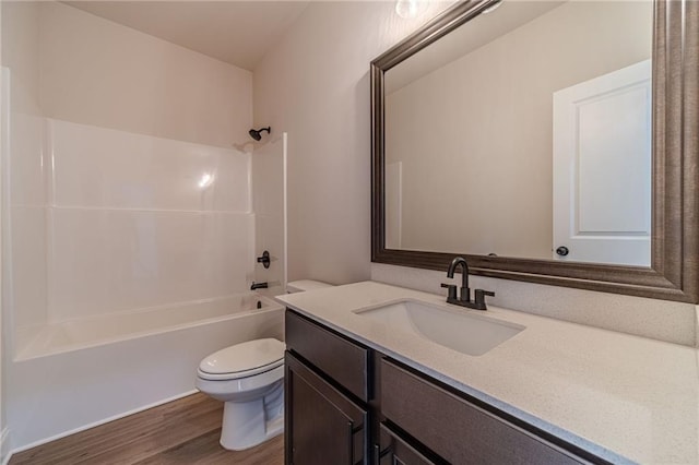 bathroom featuring vanity, toilet, wood finished floors, and bathtub / shower combination