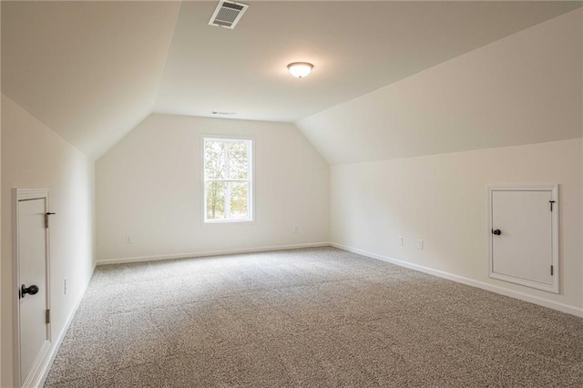 additional living space featuring lofted ceiling, carpet flooring, baseboards, and visible vents