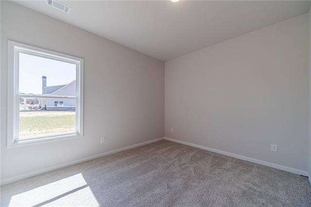 unfurnished room featuring visible vents, carpet floors, and baseboards