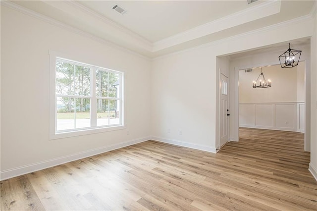 empty room featuring light wood finished floors, visible vents, and an inviting chandelier