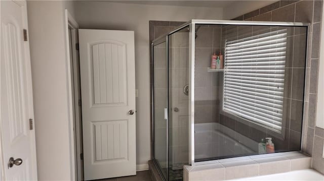 bathroom featuring a shower stall and a bath