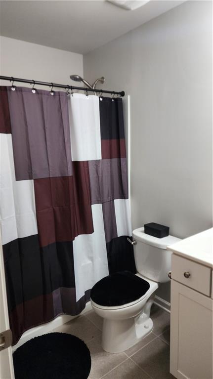 bathroom with toilet, tile patterned flooring, vanity, and a shower with shower curtain