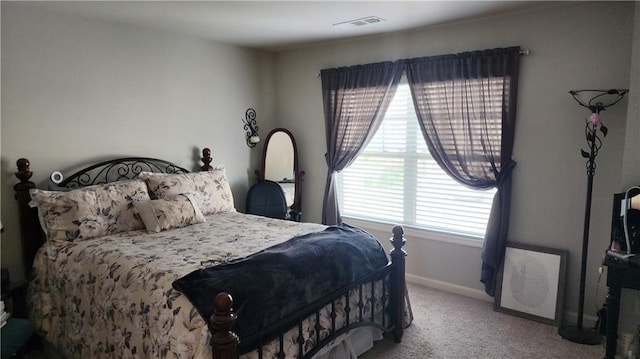 carpeted bedroom featuring visible vents and baseboards