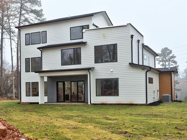 back of property featuring a lawn, cooling unit, and a patio