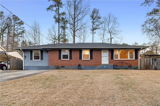 single story home featuring driveway, fence, a front lawn, and brick siding