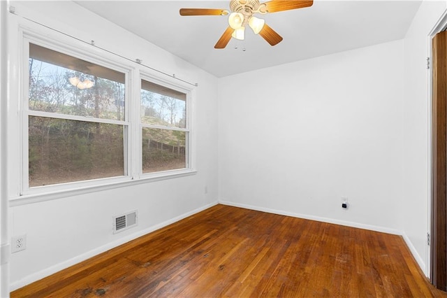 unfurnished room with a ceiling fan, wood-type flooring, visible vents, and baseboards