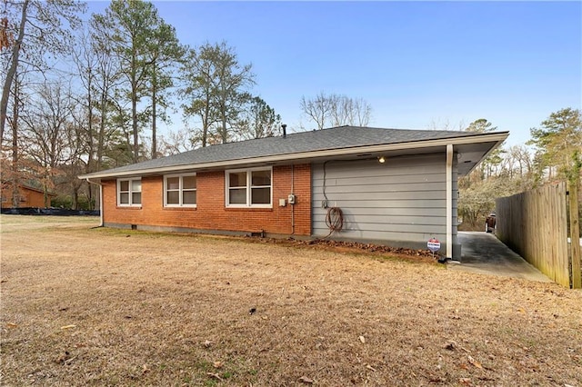 back of house featuring fence, a lawn, and brick siding