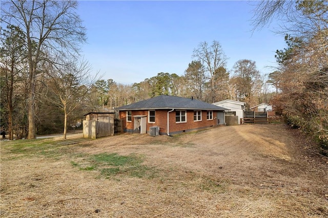 rear view of house featuring central air condition unit and brick siding