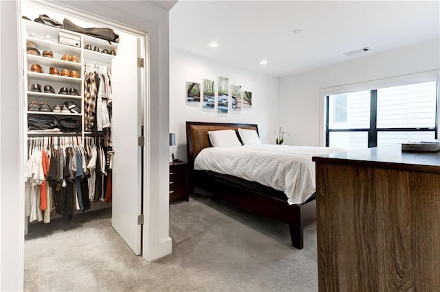 carpeted bedroom featuring a closet and a spacious closet