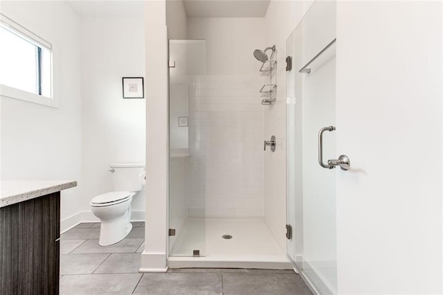 bathroom with vanity, tile patterned floors, a shower with door, and toilet