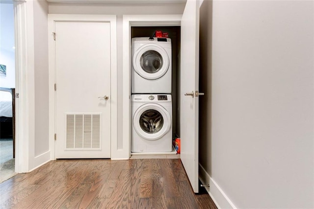 washroom featuring wood-type flooring and stacked washer and clothes dryer