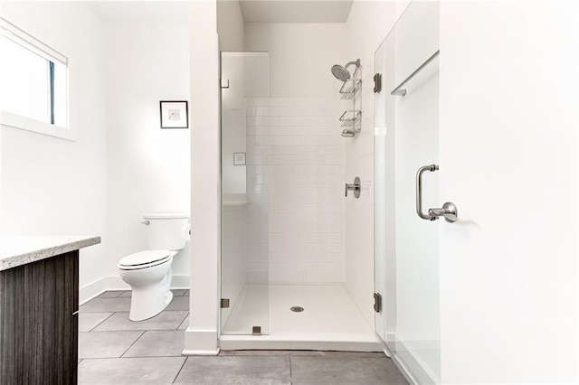 bathroom with toilet, vanity, tile patterned flooring, and an enclosed shower