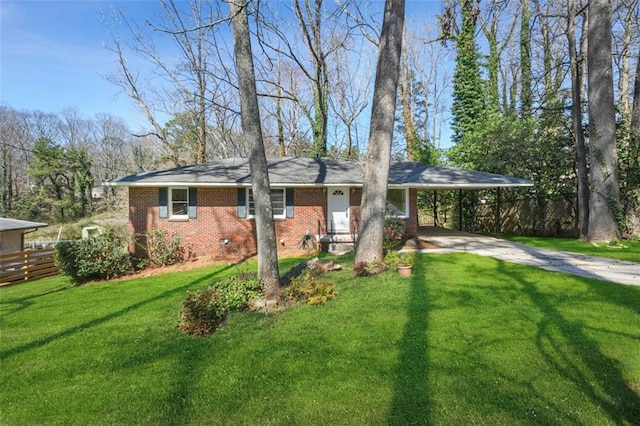 view of front of house featuring brick siding, a front lawn, fence, a carport, and driveway