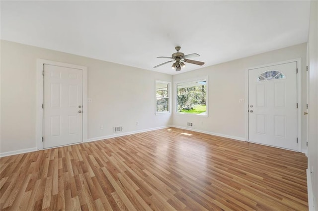 interior space with light wood finished floors, visible vents, baseboards, and a ceiling fan