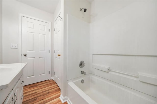 bathroom featuring vanity, bathing tub / shower combination, and wood finished floors