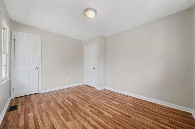 unfurnished bedroom featuring visible vents, light wood-type flooring, and baseboards