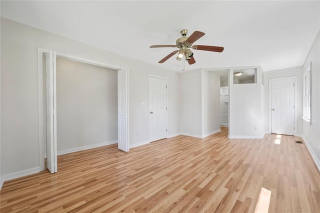 unfurnished bedroom with a ceiling fan, light wood-style floors, baseboards, and multiple closets