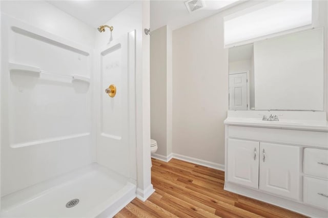 bathroom with visible vents, a shower stall, toilet, and vanity