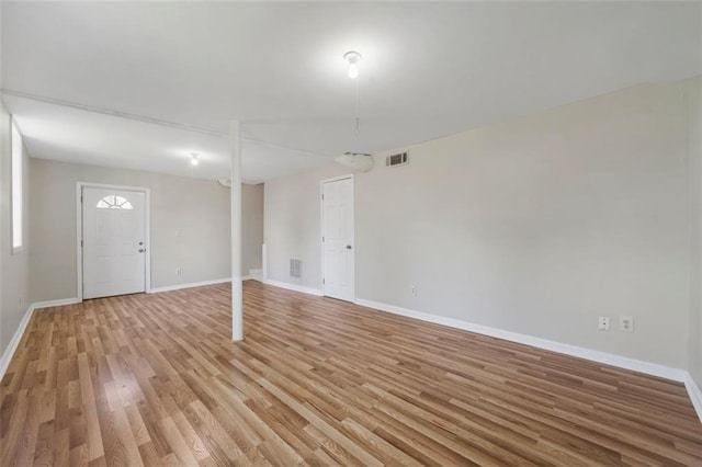 finished below grade area featuring light wood-type flooring, visible vents, and baseboards