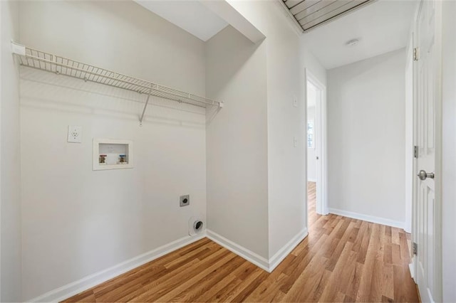 washroom with electric dryer hookup, light wood-type flooring, washer hookup, baseboards, and laundry area