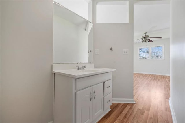 bathroom featuring baseboards, vanity, ceiling fan, and wood finished floors