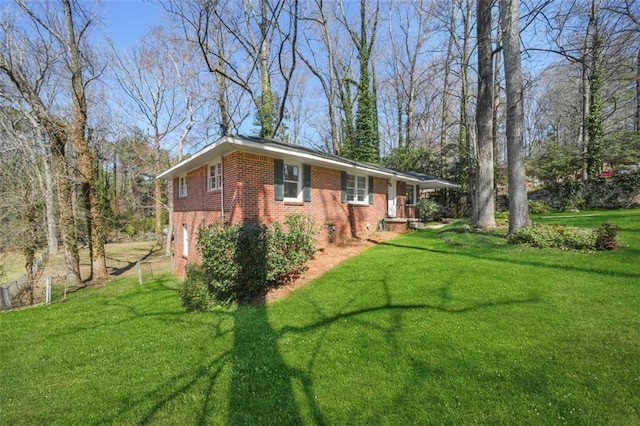 view of home's exterior featuring an attached garage, a lawn, and brick siding