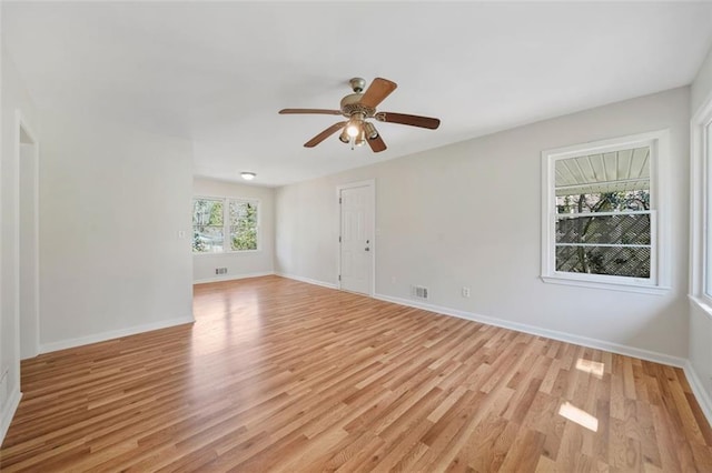 empty room with visible vents, baseboards, light wood-style floors, and a ceiling fan