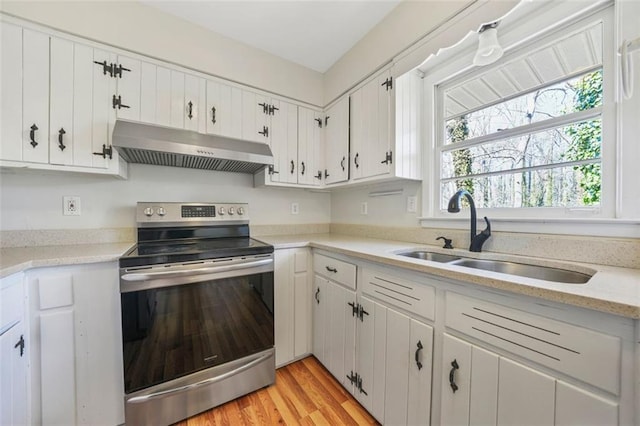 kitchen with under cabinet range hood, a sink, light wood-style floors, stainless steel electric range, and white cabinets