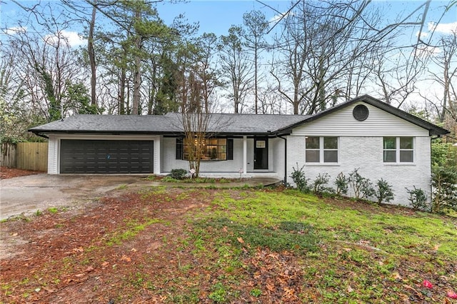 single story home featuring a front lawn, driveway, fence, an attached garage, and brick siding