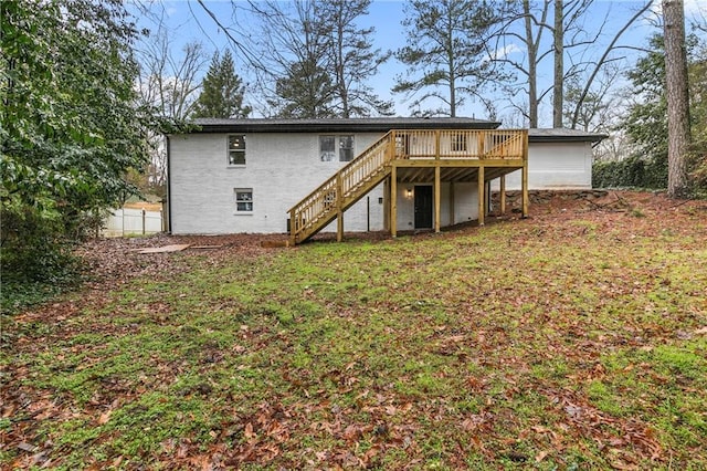 rear view of house with stairway, a wooden deck, and a yard