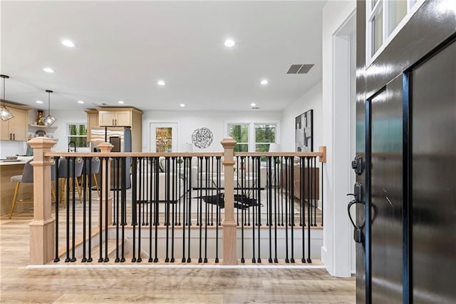 interior space featuring decorative light fixtures, recessed lighting, light wood-style flooring, and visible vents