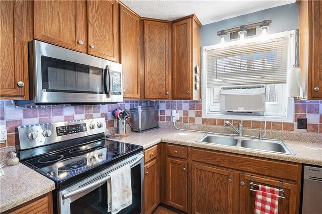 6355 Queens Rd, Douglasville, GA 30135 - kitchen with light countertops, brown cabinetry, appliances with stainless steel finishes, and a sink