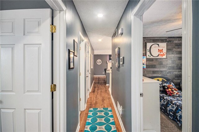 6355 Queens Rd, Douglasville, GA 30135 - hall with baseboards, light wood finished floors, wood walls, a textured ceiling, and an accent wall