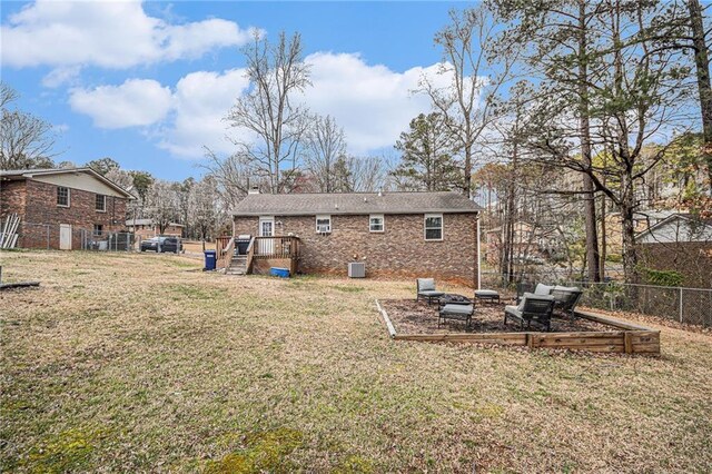 6355 Queens Rd, Douglasville, GA 30135 - back of house featuring fence, a yard, central AC, a fire pit, and brick siding