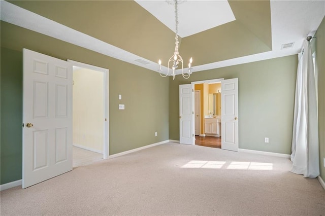 unfurnished bedroom with carpet flooring, a chandelier, baseboards, and connected bathroom