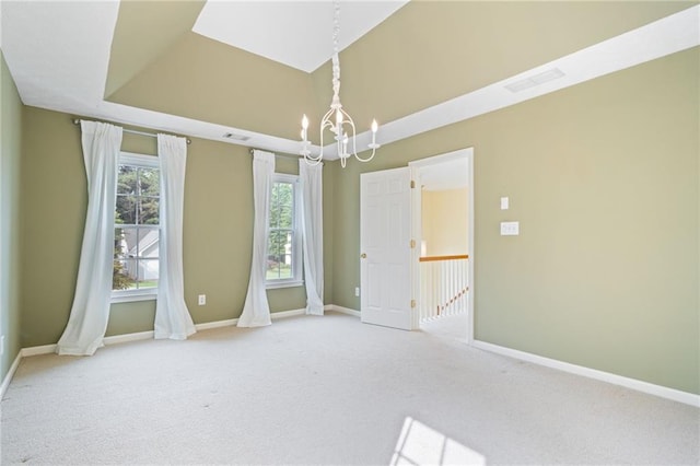 spare room with a chandelier, carpet flooring, and baseboards