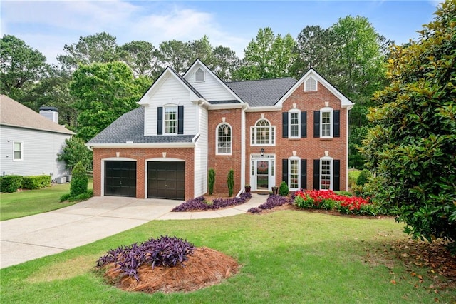 view of front of home with brick siding, a front yard, and concrete driveway