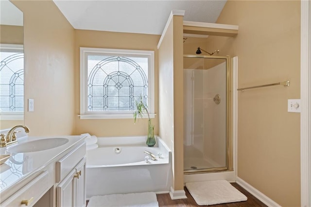 bathroom featuring a shower stall, a garden tub, vanity, and wood finished floors
