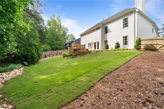 rear view of property featuring a chimney and a wooden deck