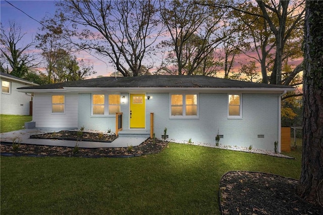 single story home with crawl space, brick siding, and a yard