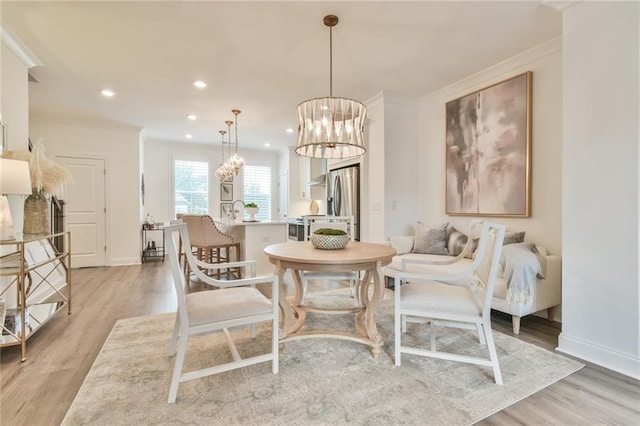 dining room featuring light wood finished floors, ornamental molding, a chandelier, and recessed lighting